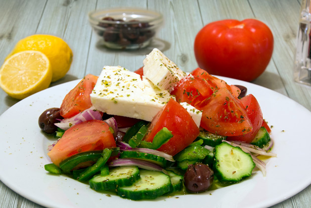 Greek Salad with tomato, cucumber, onions, olives, capers, feta cheese, oregano and olive oil